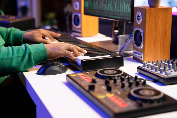 istock Music producer plays electronic keyboard piano notes over a recording 2155956756
