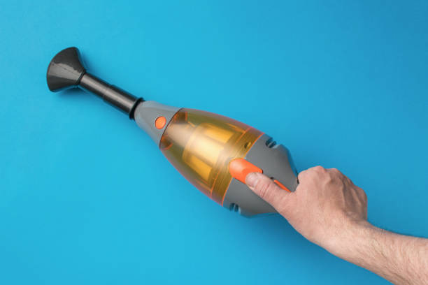Handheld Vacuum Cleaner Against Blue Background for Home Cleaning and Maintenance