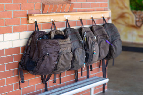 View of school bags hanging on a rack on an exterior wall of a school building