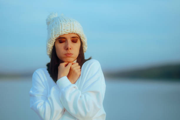 Lady shivering by the sea feeling unhappy and freezing