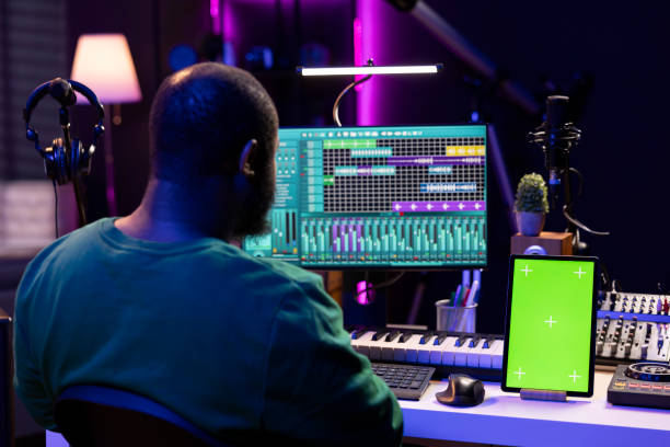 istock Songwriter composer mixing and mastering tracks next to greenscreen 2155963773