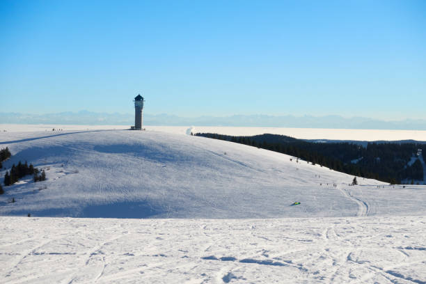 Landscape from mountain with snow in front of tower. Blue sky for copy space. Germany, Feldberg, Black forest.
