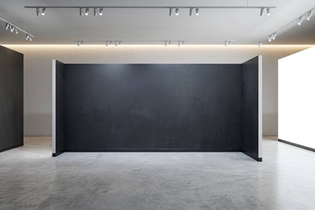 istock An empty open space with a large blank black wall and polished concrete floor, designed for presentations, exhibitions or branding. 3D Rendering 2155975662
