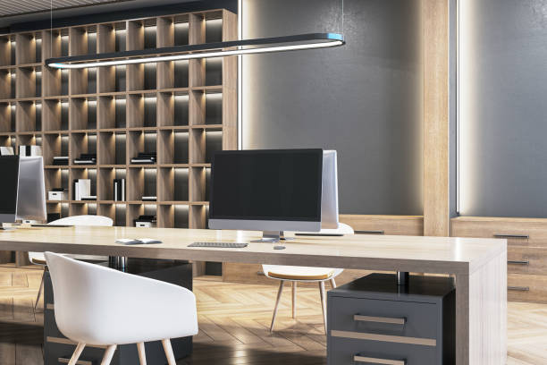 istock Modern workspace setup with dual monitors on the desk, a bookshelf in the background, and a stylish chair, showcasing a contemporary office interior. 3D Rendering 2155975699