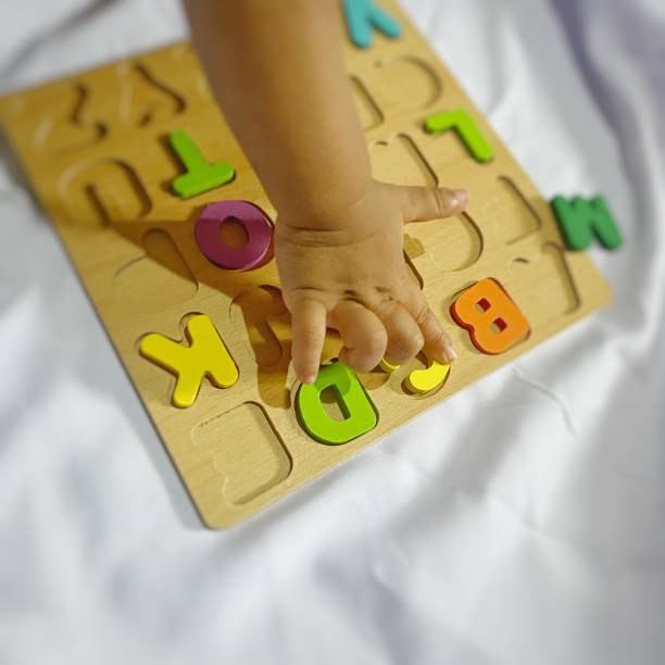 istock a child's hand playing an alphabet puzzle 2155978630