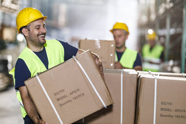 istock Happy manual worker working on carton packages in distribution warehouse. 2155979147