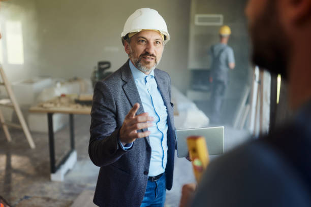 istock Male architect talking to his workers during home renovation process. 2155979609