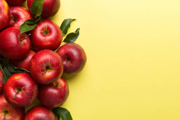 istock Many red apples on colored background, top view. Autumn pattern with fresh apple above view with copy space for design or text 2155980639