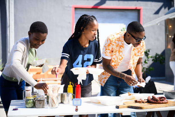 istock Three friends ad condiments to their barbecue meal 2155981818