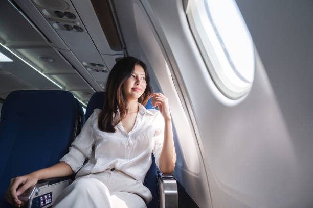 istock Asian woman looking out airplane window during flight 2155982979