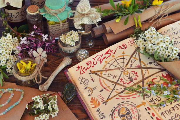 istock Mystic still life with magic book of spells, paper scrolls and witchy ritual objects on old table. Occult, esoteric, wicca and divination concept. No foreign language, all symbols are fictional 2155983781