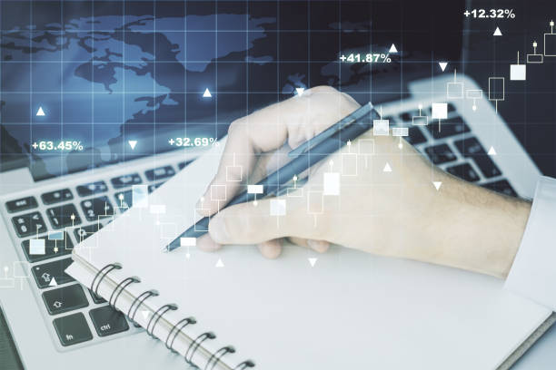 istock Multi exposure of abstract creative financial graph with world map and with hand writing in notebook on background with laptop, forex and investment concept 2155984615