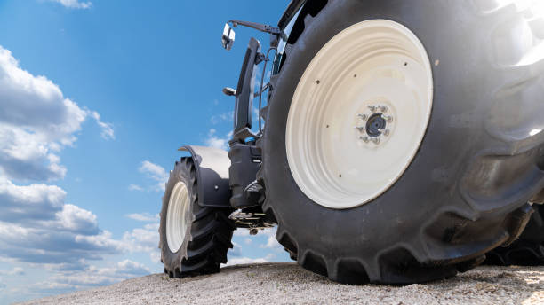 Close-up of the rear wheel of a large heavy farm tractor. The work of agricultural machinery and farmers.