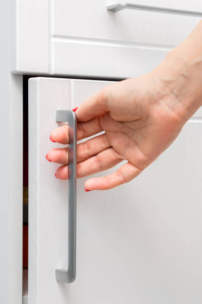 istock housewife opens a white kitchen cabinet, close-up 2155987583