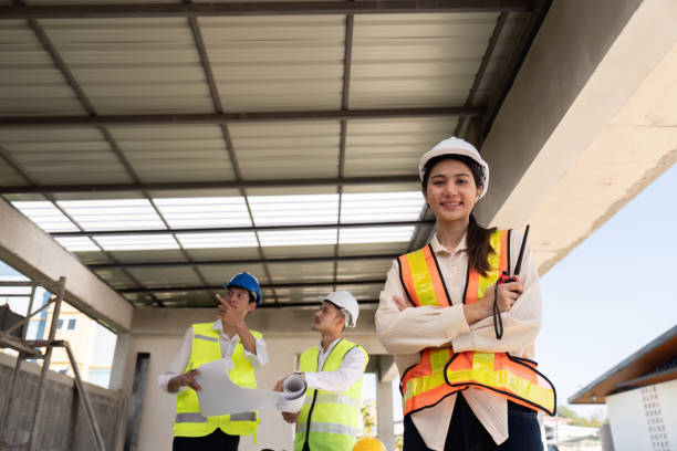 istock Confident Asian female engineer with colleagues at construction site, leadership concept 2155989109