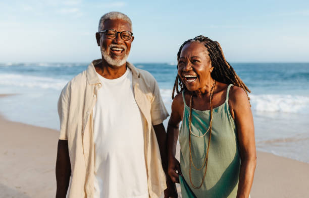 istock Cheerful elderly African American couple walking on the beach 2155990522