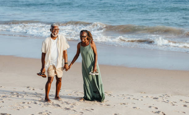 istock Elderly black couple enjoying a walk on the beach 2155990586