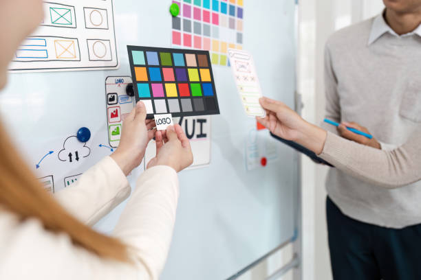 istock UI designers present to team about color design of logo during application design brainstorming. Creative digital development agency. UX UI concept 2155991426