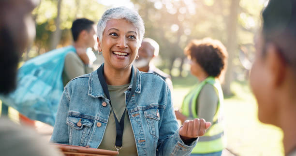 istock Park, woman and volunteers discussion with tablet for support, community project or nature sustainability. Humanitarian, recycling or senior leader in charity service and NGO for pollution cleanup 2155992130