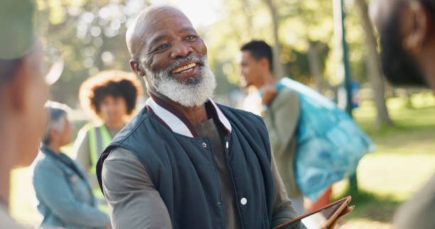 istock Park, black man and volunteers planning with tablet for support, community project or nature sustainability. Humanitarian, recycling or senior leader in charity service or NGO for pollution cleanup 2155992135