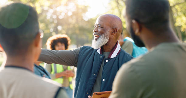 istock Park, black man and volunteers discussion with tablet for support, community project or nature sustainability. Humanitarian, recycling or senior leader in charity service or NGO for pollution cleanup 2155992139