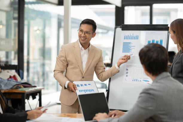 istock Group of Asian businessmen are presenting graphs on a whiteboard. 2155994102