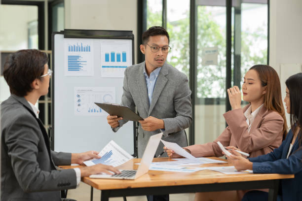 istock Group of Asian businessmen are presenting graphs on a whiteboard. 2155994160