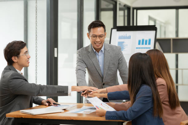 istock Group of Asian businessmen are presenting graphs on a whiteboard. 2155994173