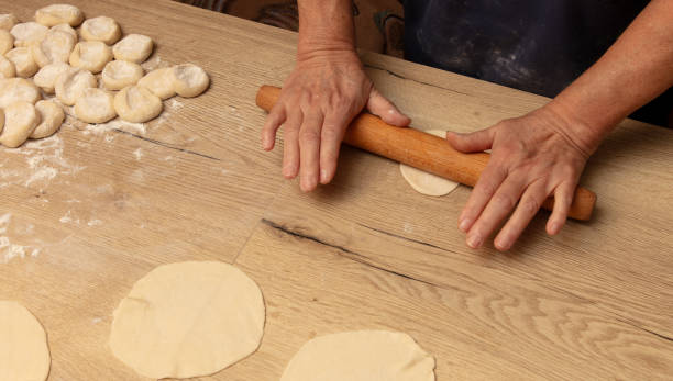 istock A woman rolls out dough with a rolling pin 2155995297
