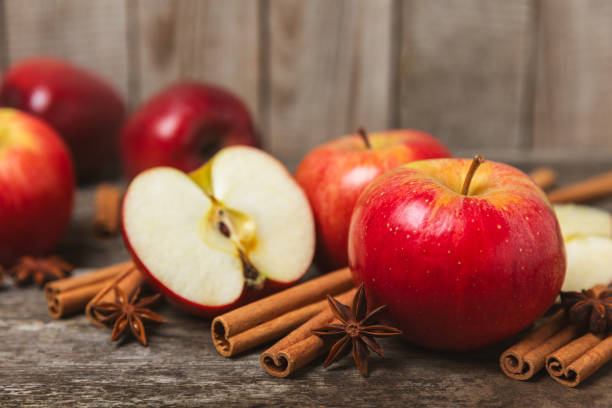 istock Apples with cinnamon on a textured wooden background. Fragrant red spiced apples with cinnamon sticks and star anise. Apple slices with spicy spices. Place for text. Copy space. Harvesting. Fruits. 2155995959