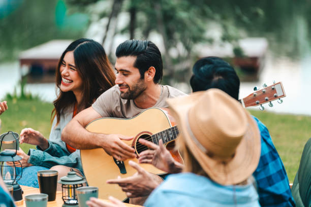 istock Young friends share a fun summer weekend outdoors with a campfire, bar-b-q, and picnic, celebrating vacation, friendship, and happy moments together. 2155997737