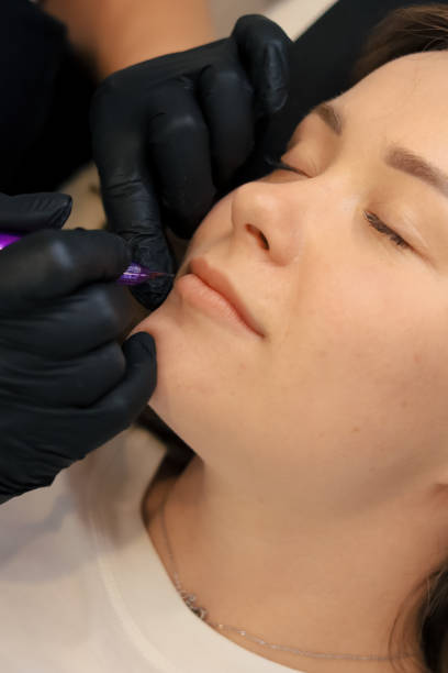 istock procedure of permanent makeup in tattoo salon 2155998294