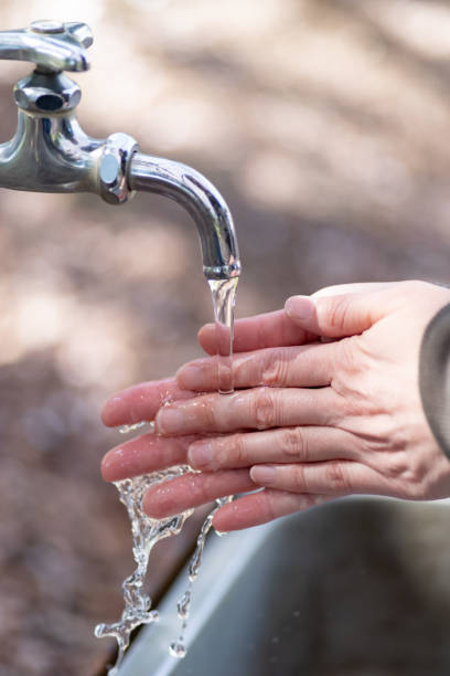 istock person washing hands outdoors 2156000282