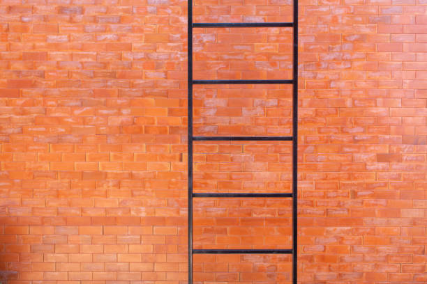 A fire escape staircase runs across an orange brick wall.