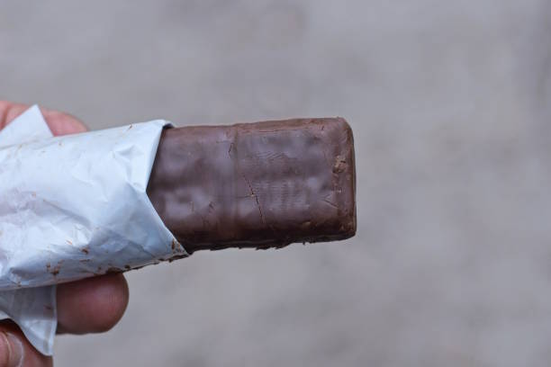 istock hand holding one brown chocolate bar outdoors 2156000587
