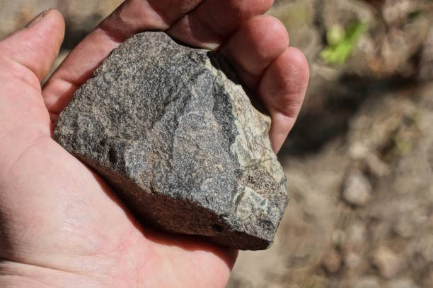 istock a one man hand holds a large gray white piece of stone 2156000655