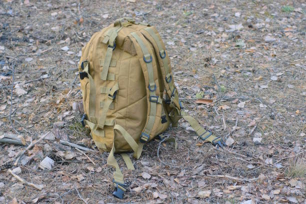 istock one brown army backpack standing on a earth outdoors 2156000769