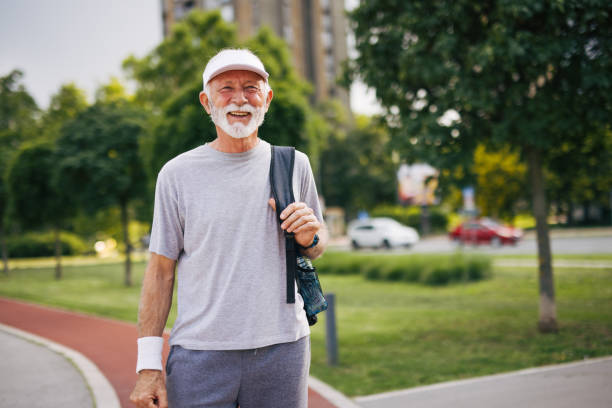 istock elderly  man exercising outdoor, carrying bag 2156001282