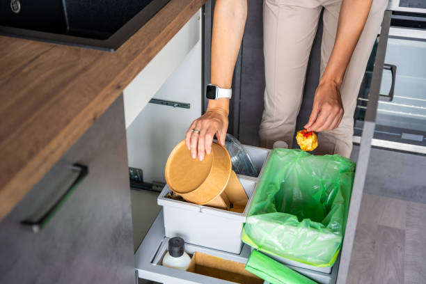 istock Woman throwing trash into household bins for waste sorting in the kitchen for recycle. Plastic, paper, bio and mixed waste. Sorting waste at home concept 2156001824