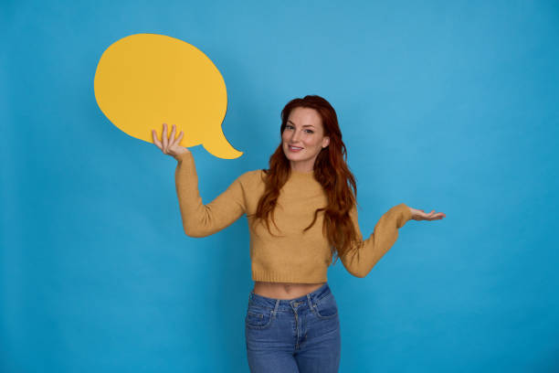 istock Woman holding speech bubble sharing information on blue background 2156001957