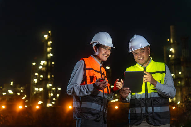 istock Handsome Asian man petrochemical engineers using digital tablet working together after going through routine checks with petroleum oil refinery in industrial estate background. Engineers at industry. 2156002248