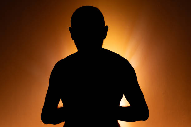 istock Man in silhouette, standing still and shirtless, posing for a photo. 2156003330