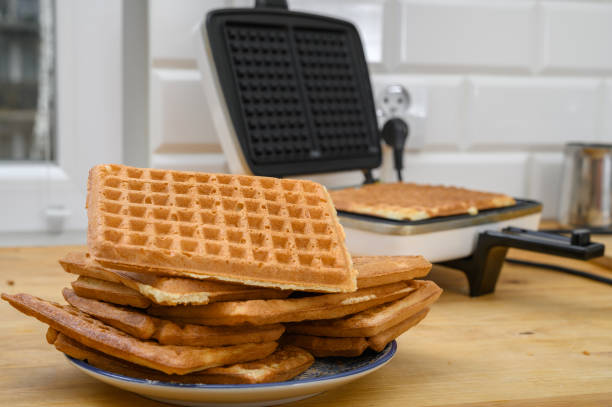 Make delicious crispy waffles, stack golden wafers on a plate and in the waffle maker