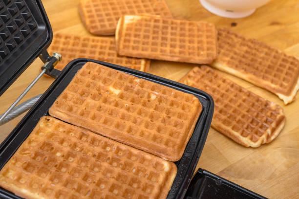 istock Waffle maker with rectangular waffles, baked crispy sweet waffles with holes close up 2156003762