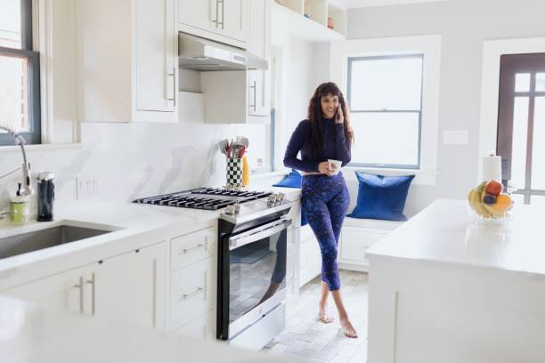 Woman talking on a smartphone in the kitchen