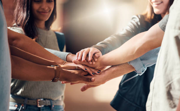 Diversity, hands together and team support for student collaboration, education motivation and team building project success. Interracial group of collge friends, solidarity and goals mission
