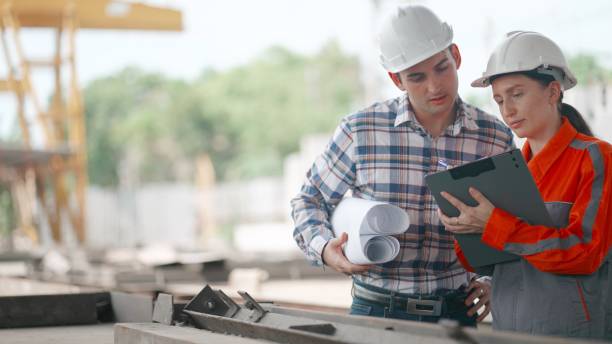 istock Industrial engineer or building contractor wearing safety equipment, working together discuss about concrete wall designs and inspect production processes.in factory producing prefabricated walls for building houses. Manufacturering. Construction industry 2156006878