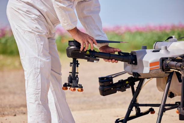 istock A male in a white uniform preparing an agrodrone for flying over a field. 2156007082