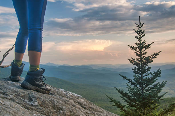 hiker on top of a large rock at sunset