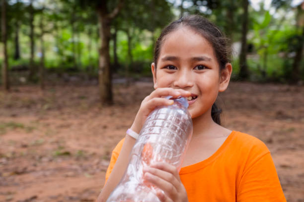 Happy Cambodian girl drinking a water in village near Siem Reap, Cambodia